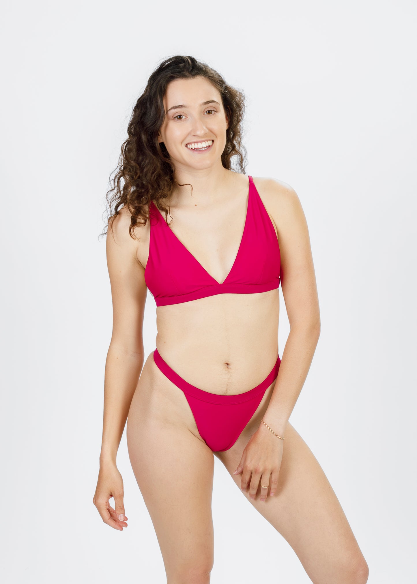 Front view of a woman wearing high-cut pink bikini bottoms from Tamara, showcasing a flattering, sustainable design ideal for beach and water sports.
