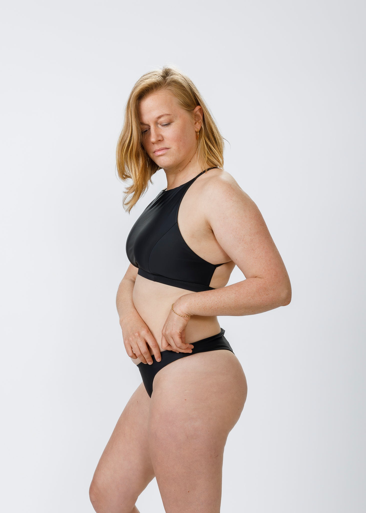 Woman wearing classic black bikini bottoms from Tamara, showing a comfortable and stylish side profile.