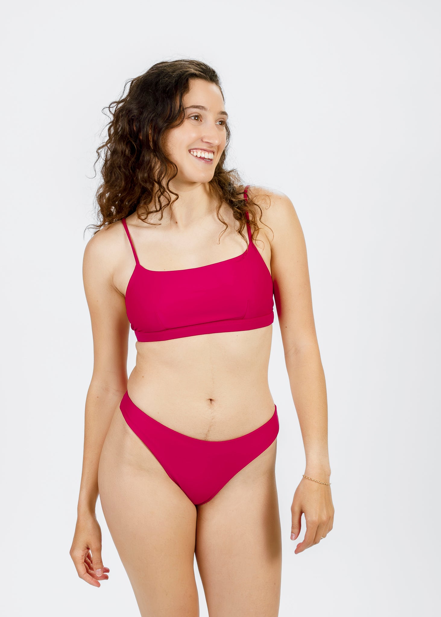 A smiling woman in a comfortable pink square-neck bikini top by Tamara, showcasing its flattering and supportive design.