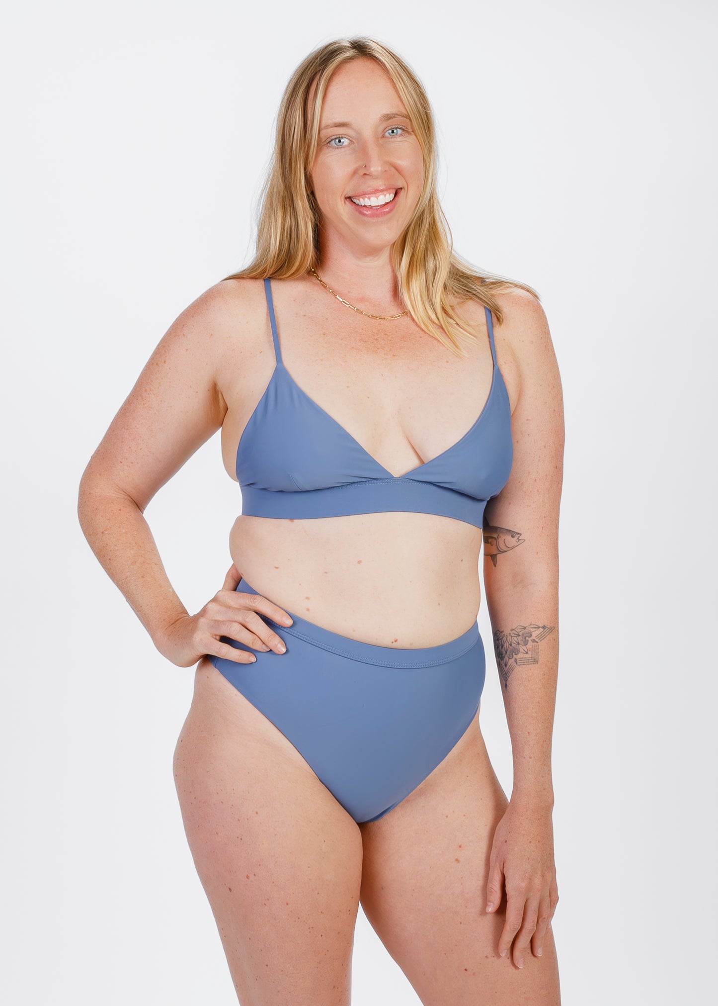 The same woman faces forward, smiling while wearing a bikini with a high-waisted bottom. She gently rests her hand near the waistband, highlighting the comfortable and supportive rise.