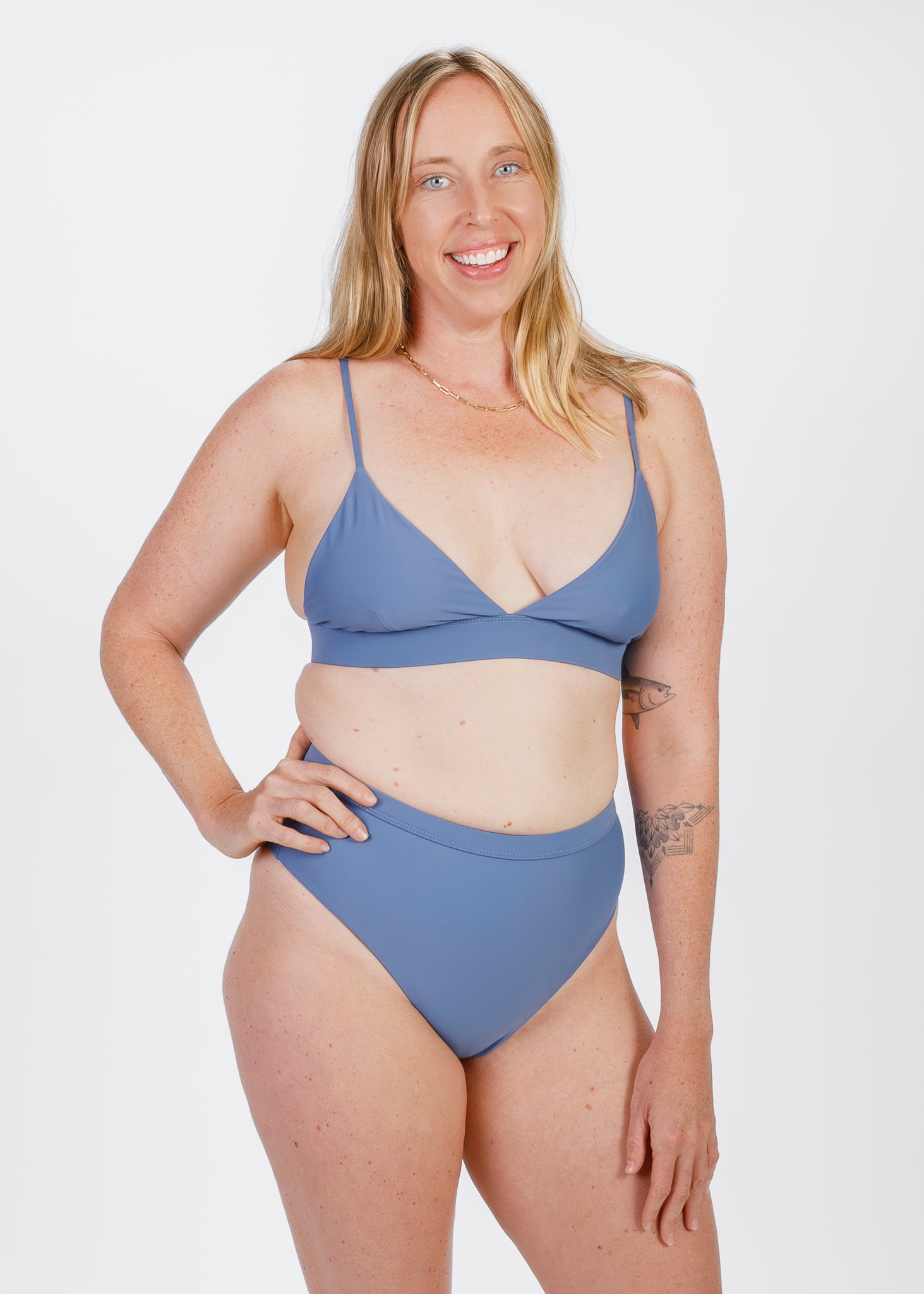 The same woman faces forward, smiling while wearing a bikini with a high-waisted bottom. She gently rests her hand near the waistband, highlighting the comfortable and supportive rise.