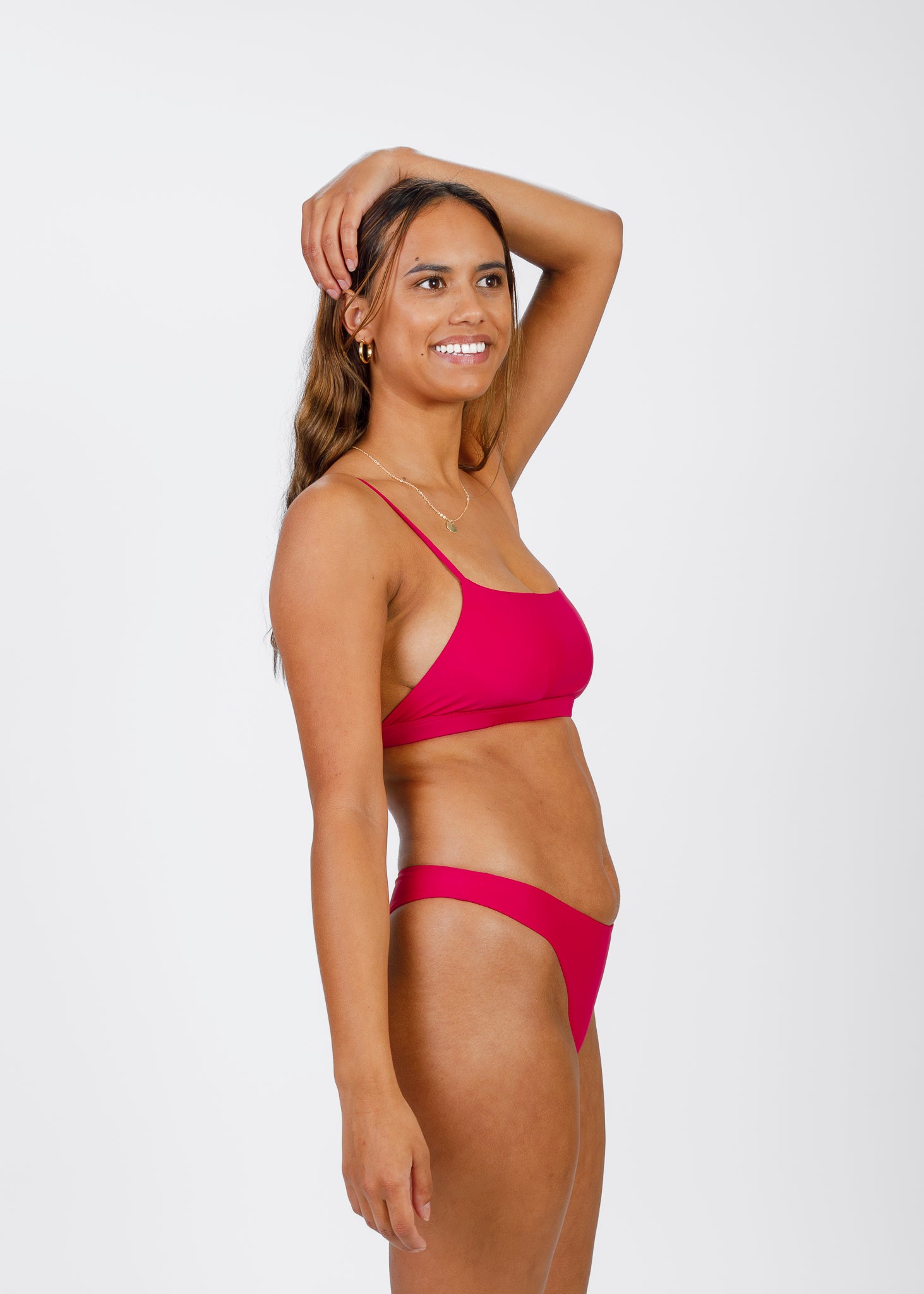 Side view of a woman wearing Tamara’s pink bikini top, featuring thin, elegant straps and a modern square neckline designed for comfort and style.